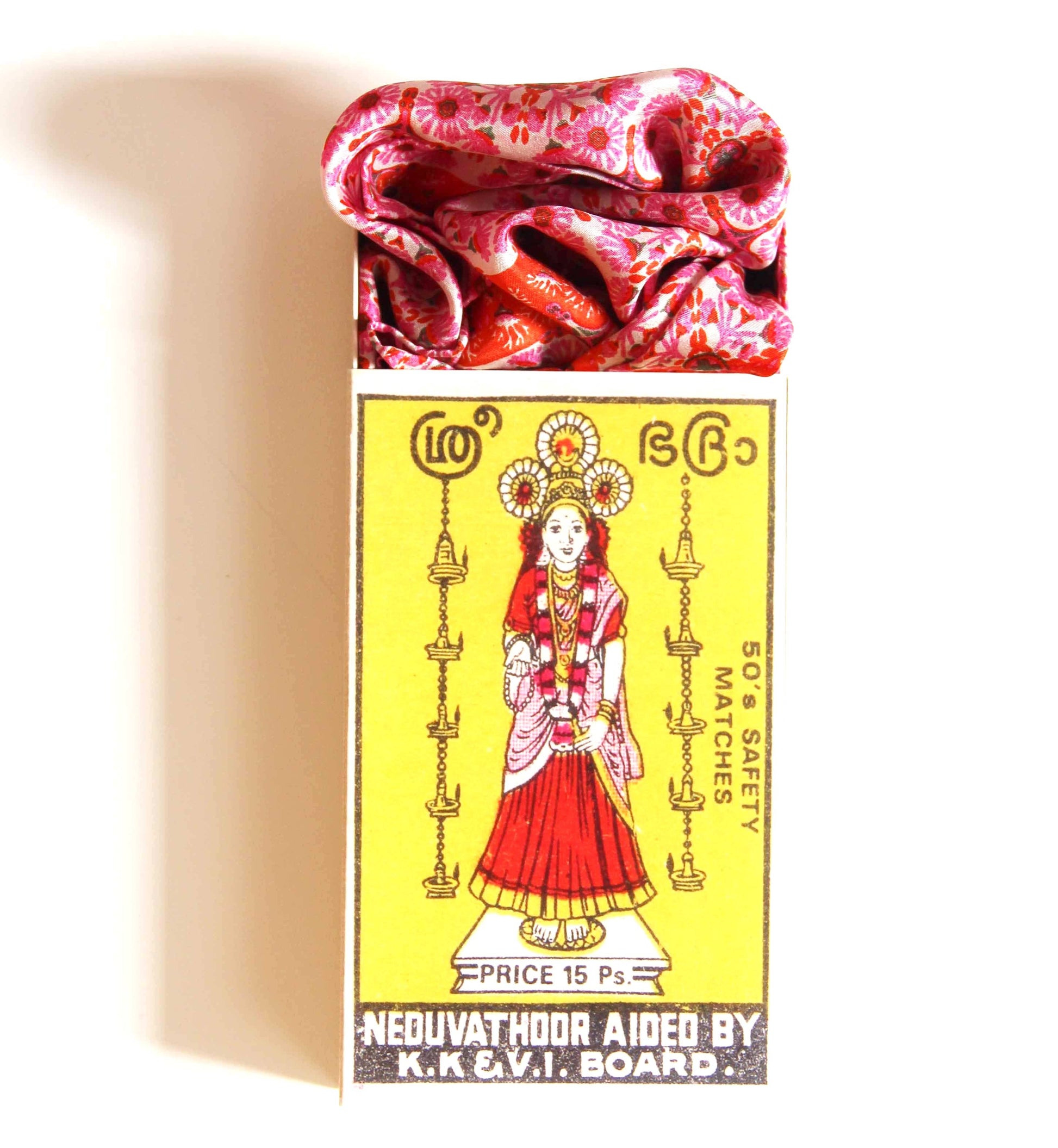 Matchbox with a colorful design featuring a woman in traditional attire on a yellow background.