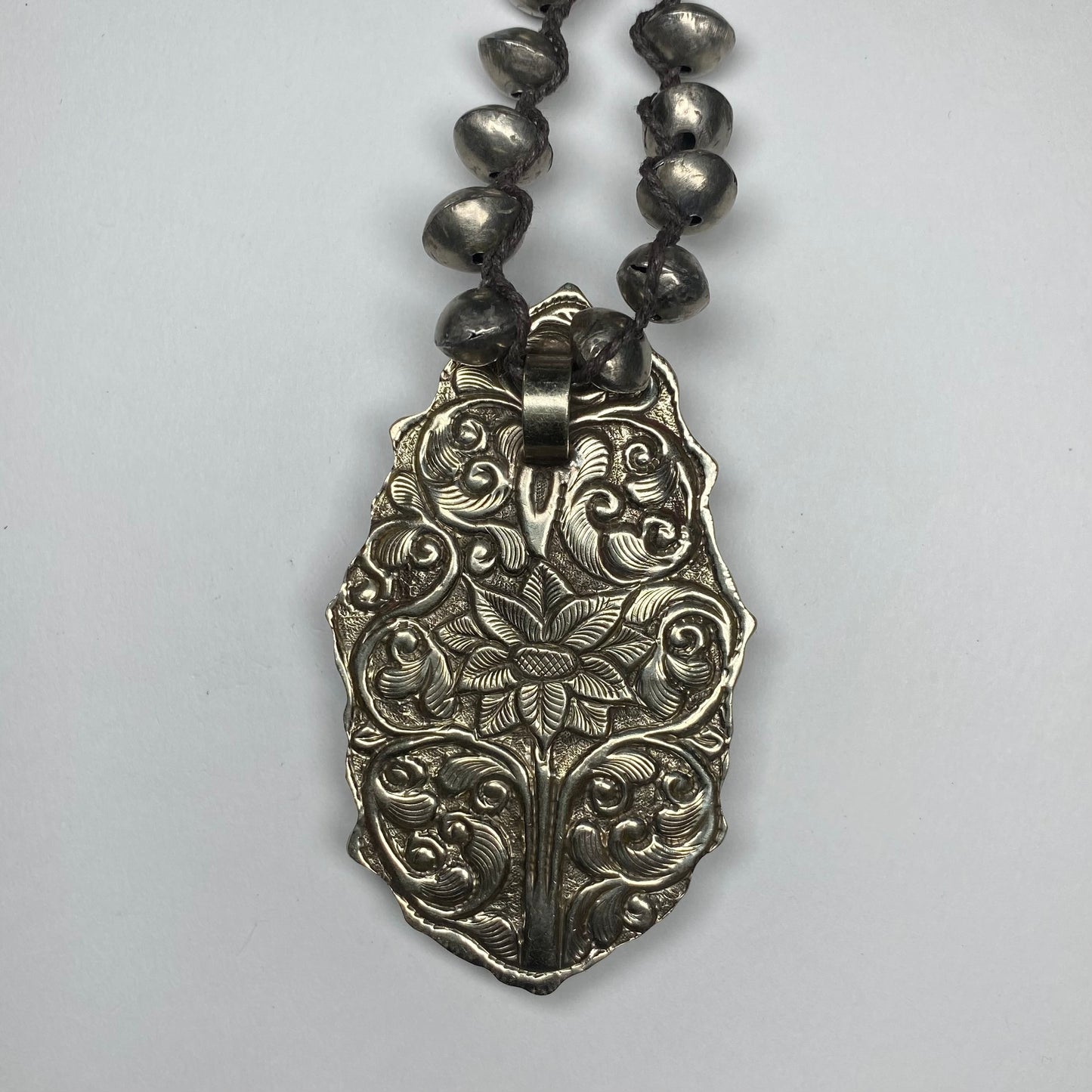 Back of floral engraved Silver pendant.