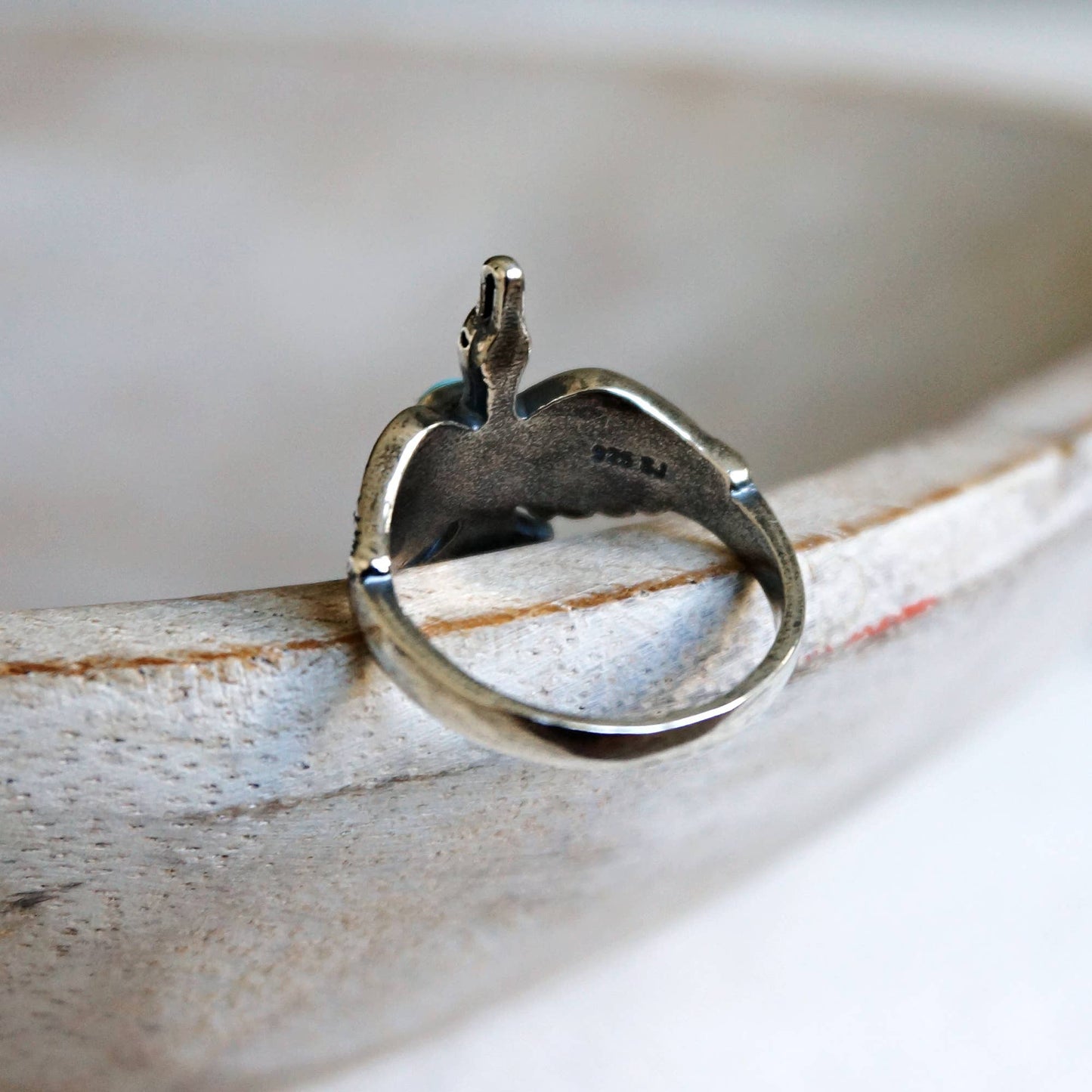 Silver ring with a unique design on a wooden surface