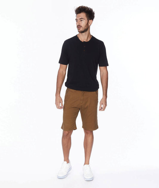 Male model wearing tobacco colored shorts with a black tee and white sneakers.