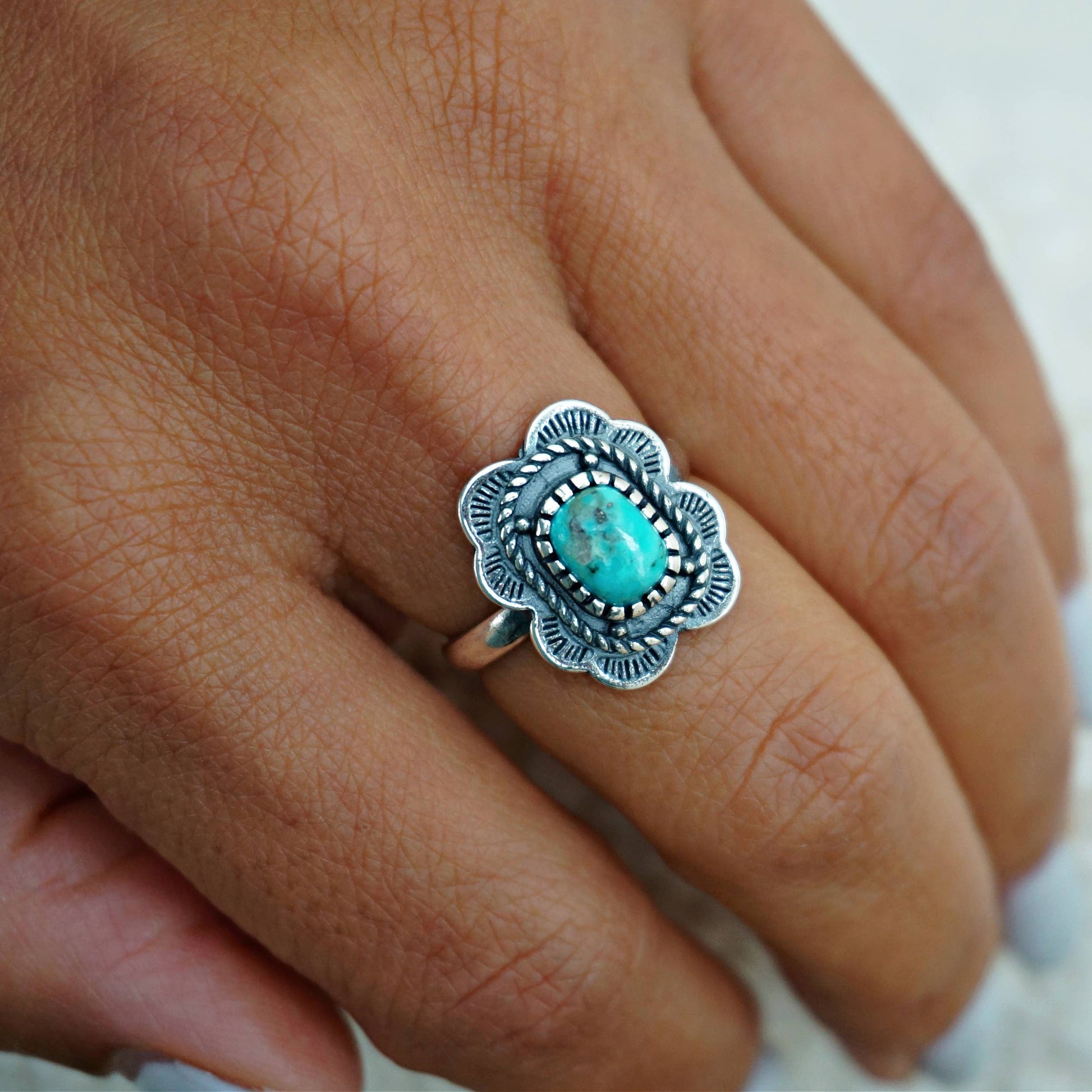 Silver ring with turquoise stone on a finger