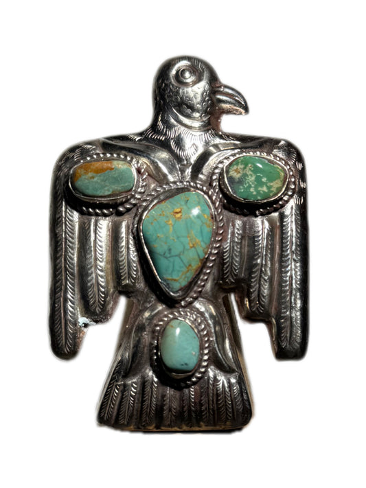 Silver eagle pendant with turquoise stones on a white background