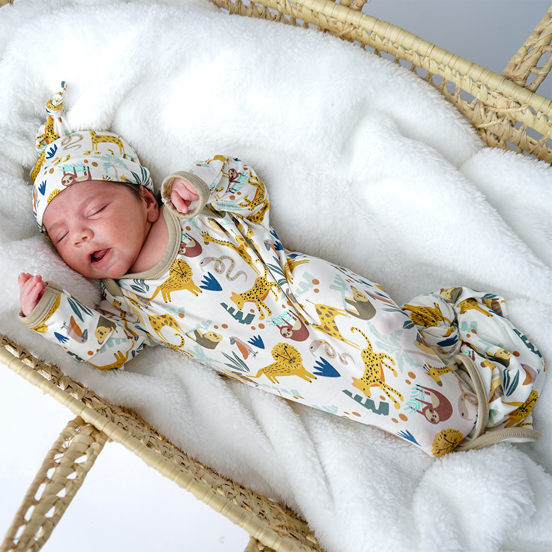 Newborn baby in a swaddle with animal pattern in a moses basket