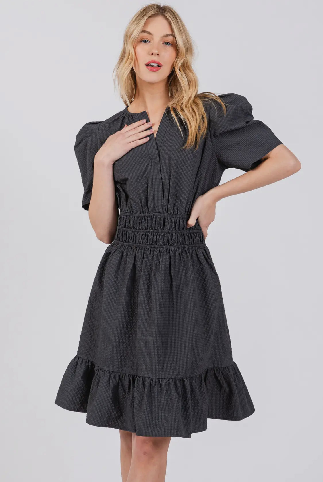 model wearing black puff sleeved ruffle dress