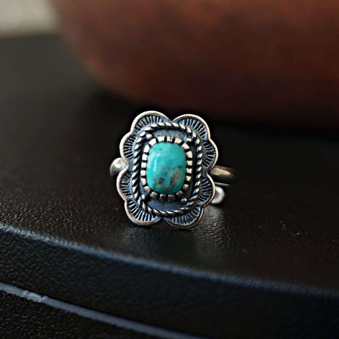 Silver ring with turquoise stone on a black surface