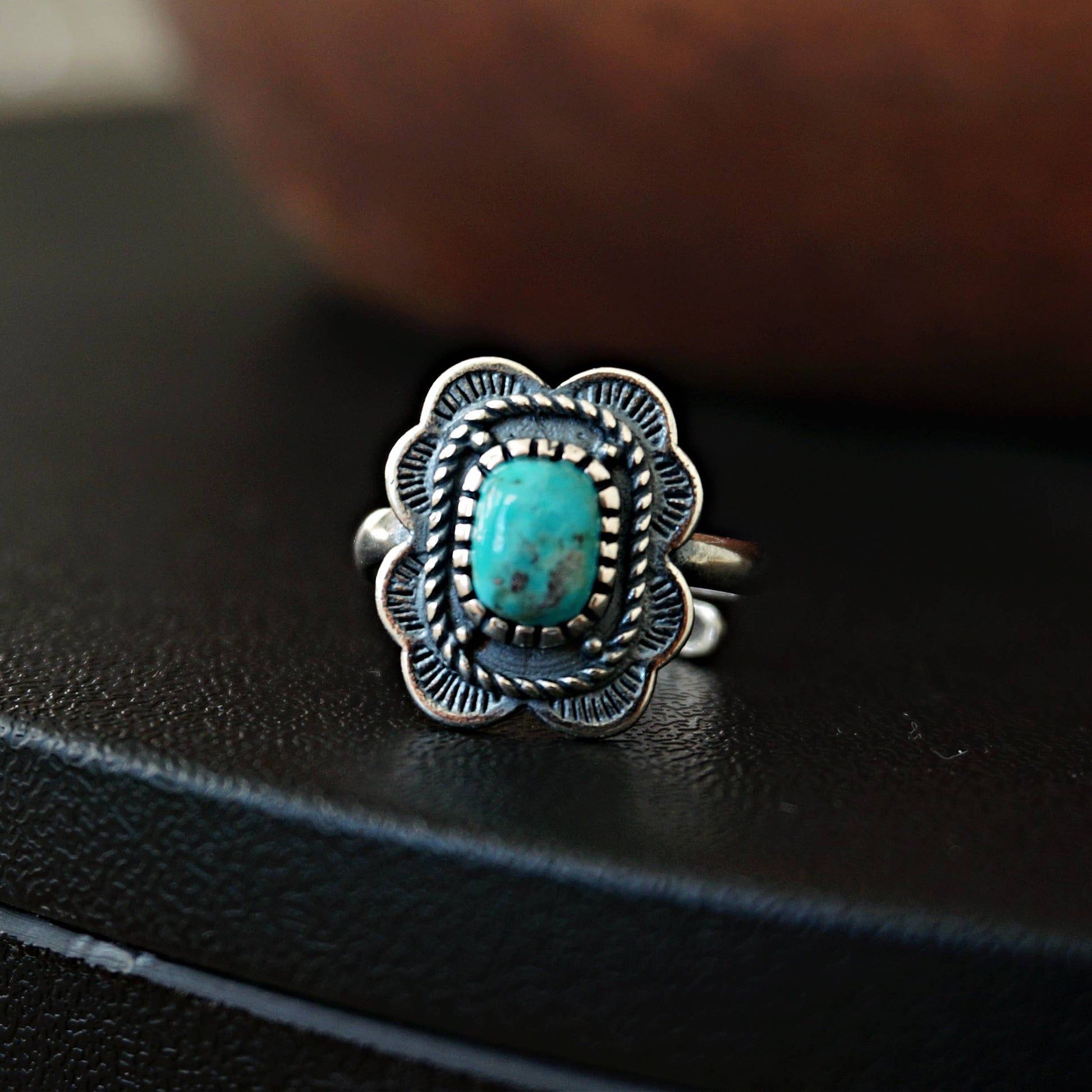 Silver ring with turquoise stone on a black surface