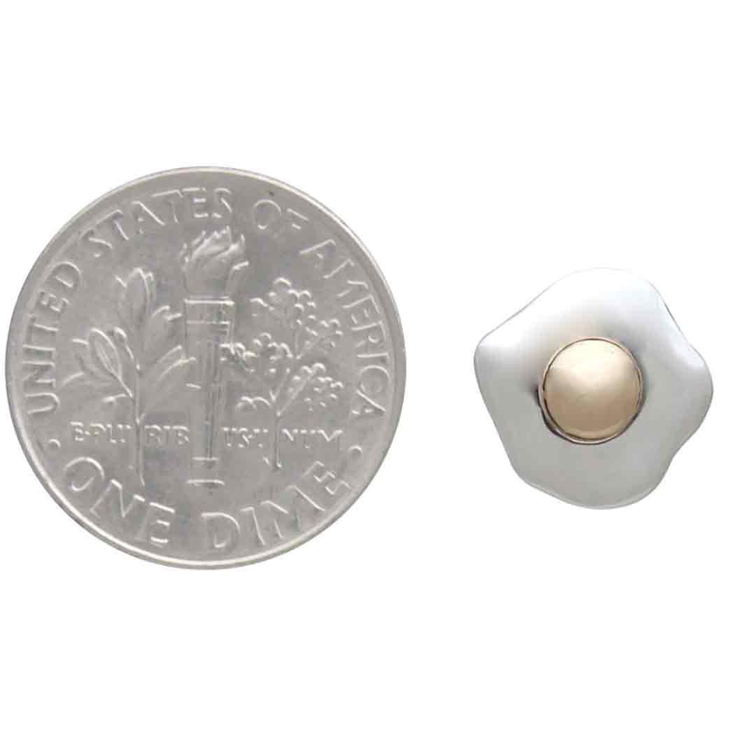 Silver dime next to a silver and gold egg earring on a white background