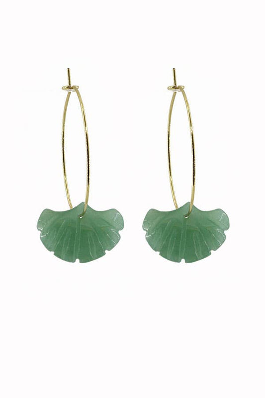 Green leaf-shaped earrings on gold hoop wires against a white background