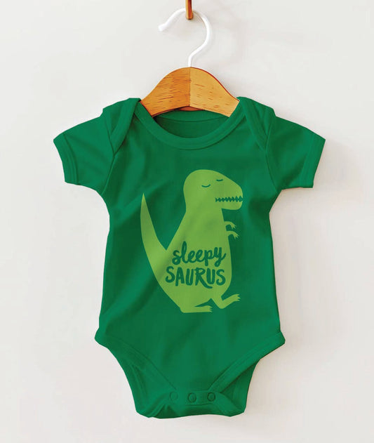 Green baby onesie with a dinosaur design and 'sleepy saurus' text on a white background.