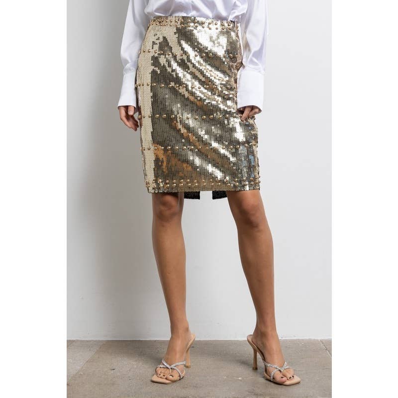 Person wearing a gold sequin skirt with a plain background