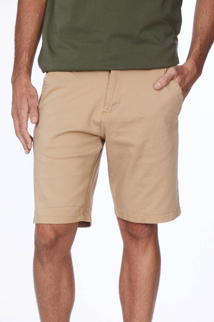 male model wearing light khaki shorts with a green tee