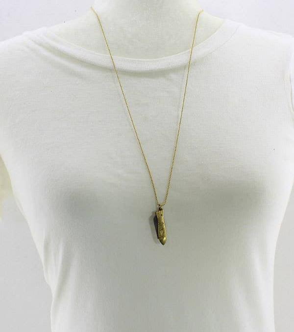 Brass mini knife in the shape of a fish close up of mannequin wearing white t-shirt and white background