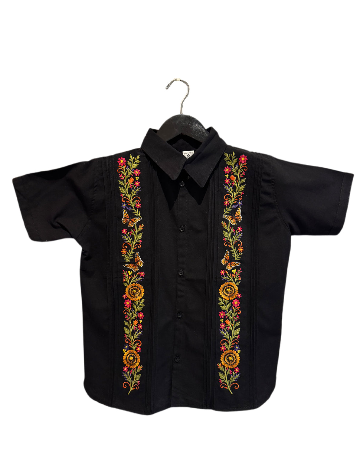 A black short-sleeve button-up shirt with colorful floral and butterfly embroidery down the front center, hanging on a black hanger against a plain white background.