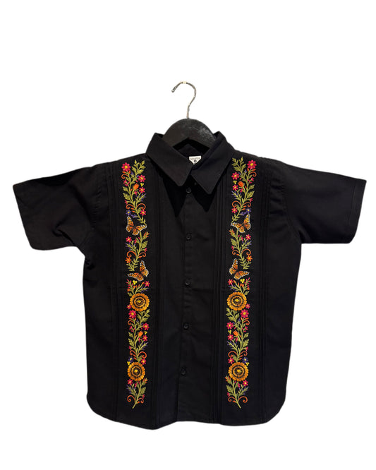 A black short-sleeve button-up shirt with colorful floral and butterfly embroidery down the front center, hanging on a black hanger against a plain white background.