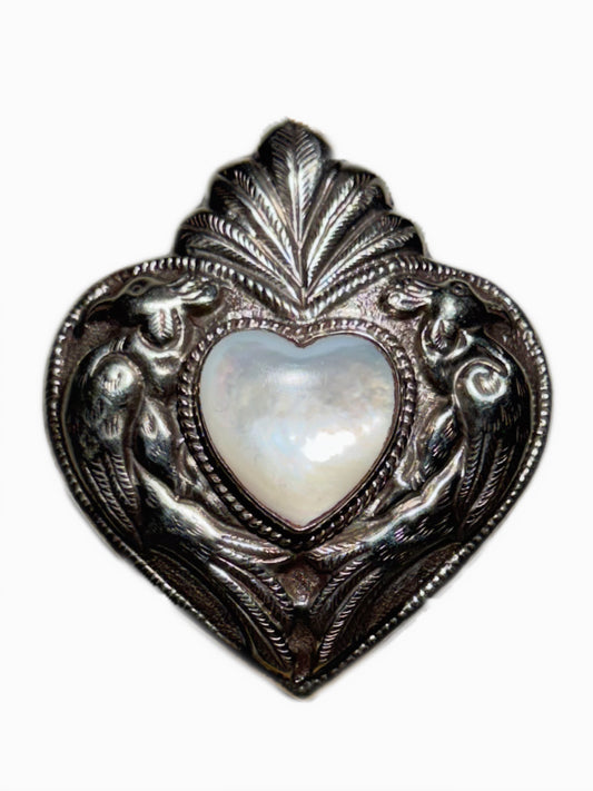 Decorative heart-shaped ring with a shell center on a white background