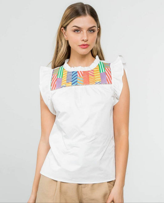 model wearing white flutter sleeve top with colorful pattern across chest