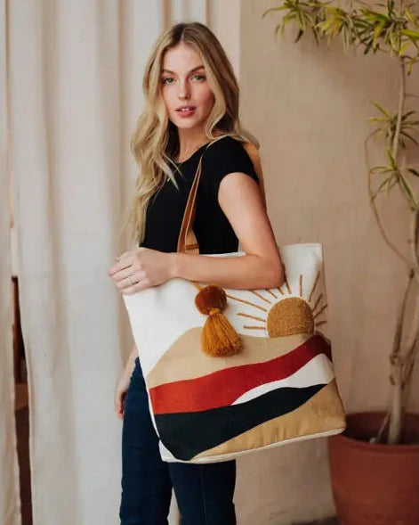 woman holding sunset design tote bag