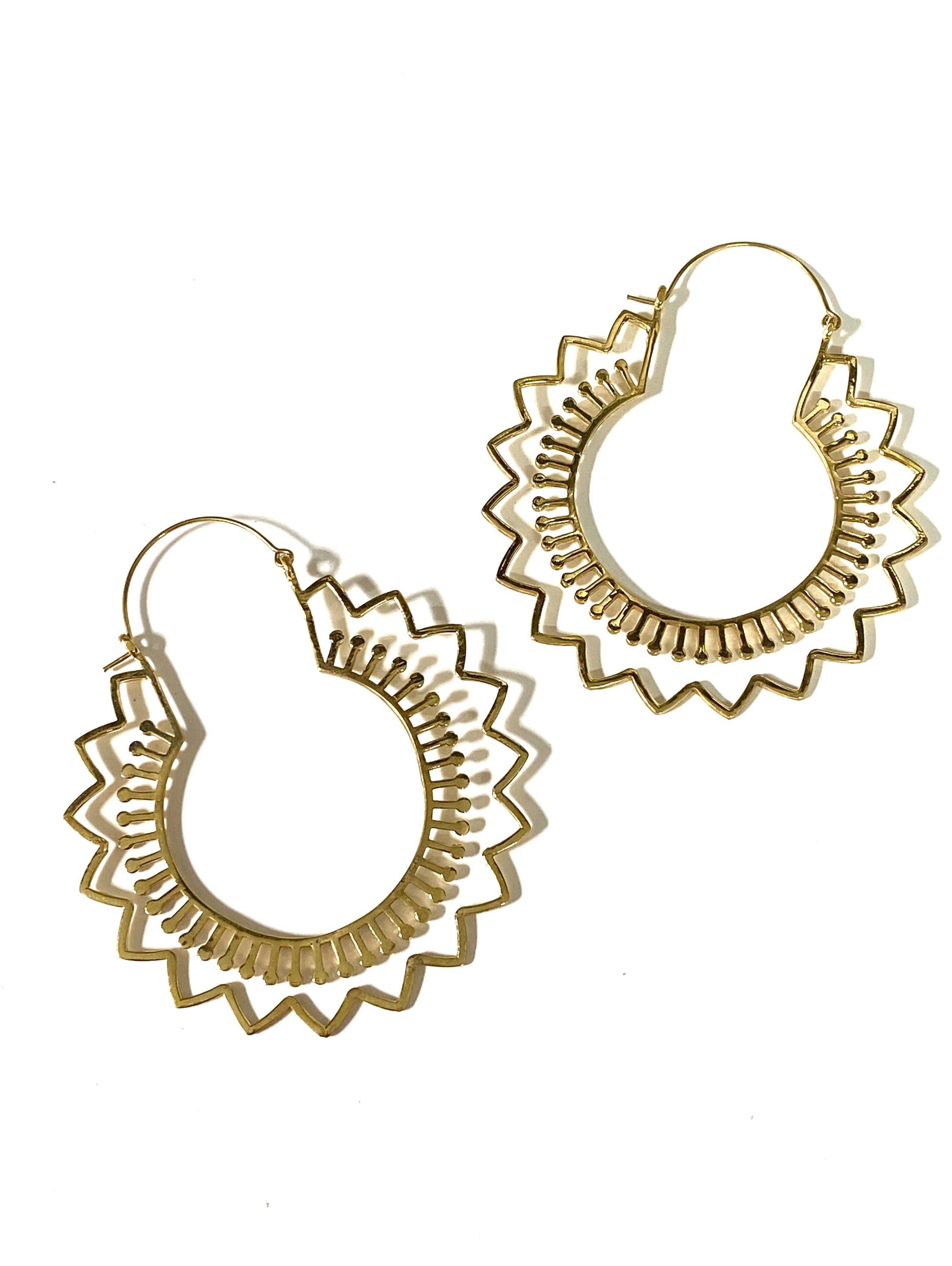 Hoop earrings with ridges and stick designs on a white background.