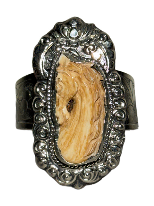 Decorative cuff with a natural bone horse and silver frame on a white background