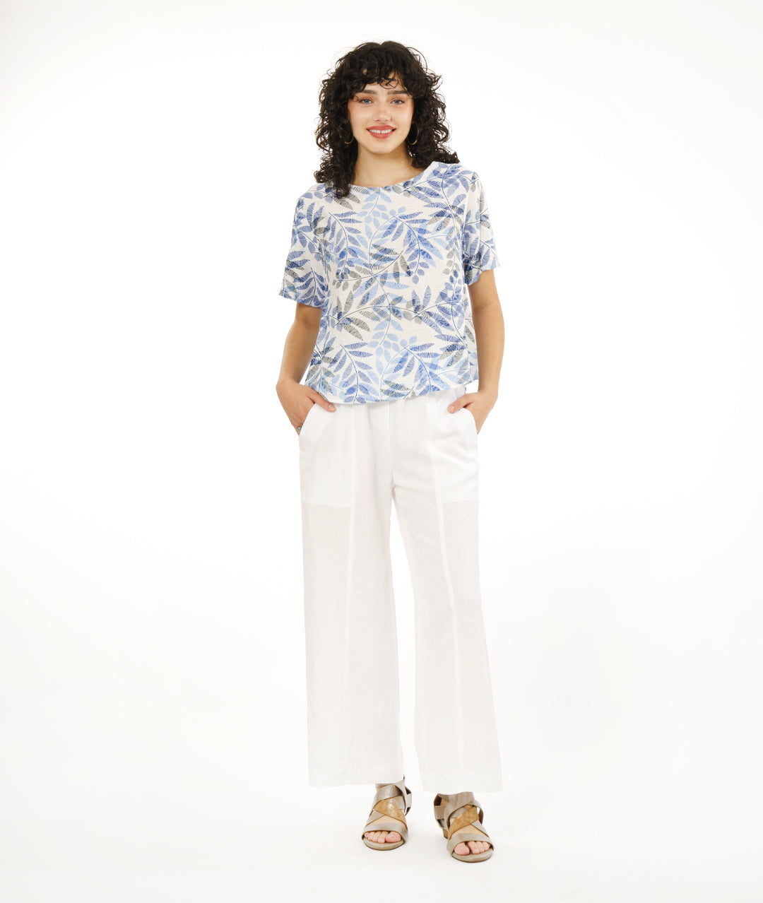 model in a wide white pant with a boxy pullover tee in white, with a blue and black leaf print