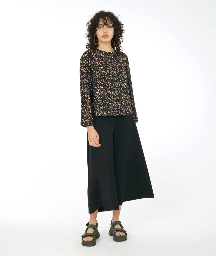 model wearing black terrazzo print long sleeve top with black pants and sandals