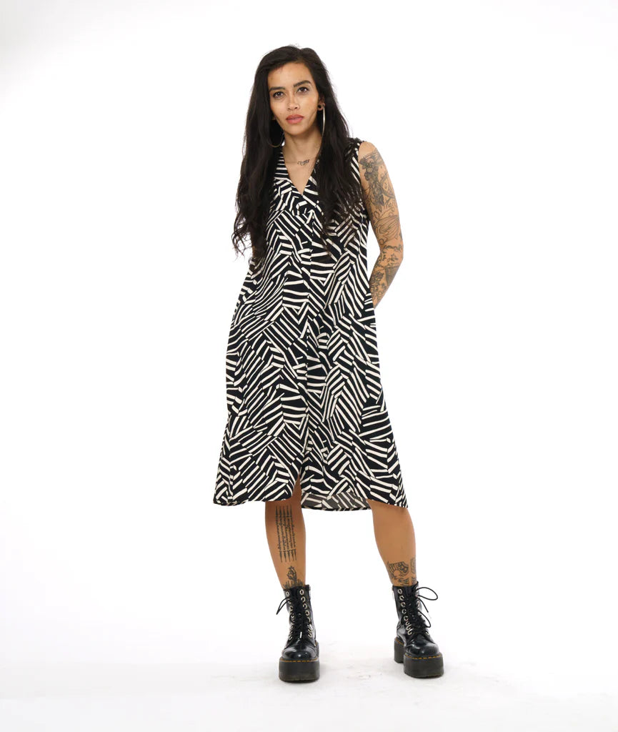 model wearing v neck mid length dress with black and white design, paired with black boots