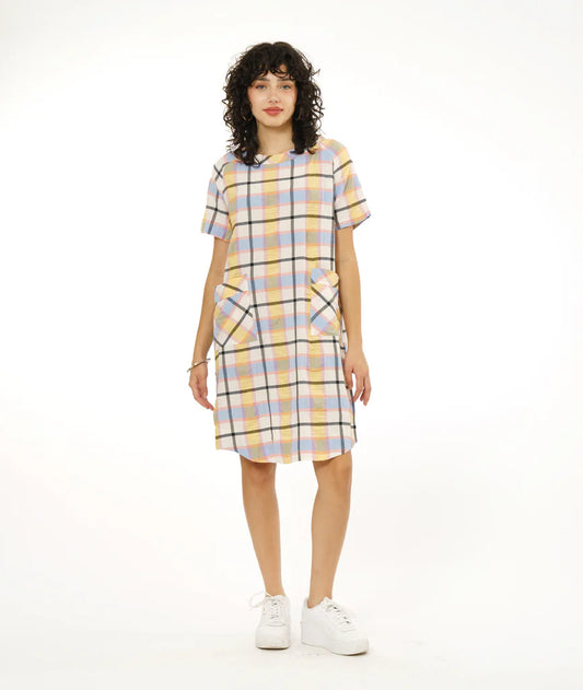 model wearing round hem dress that hits below the knee with patch pockets, short sleeves and boat neck collar in a plaid pastel pattern paired with white sneakers