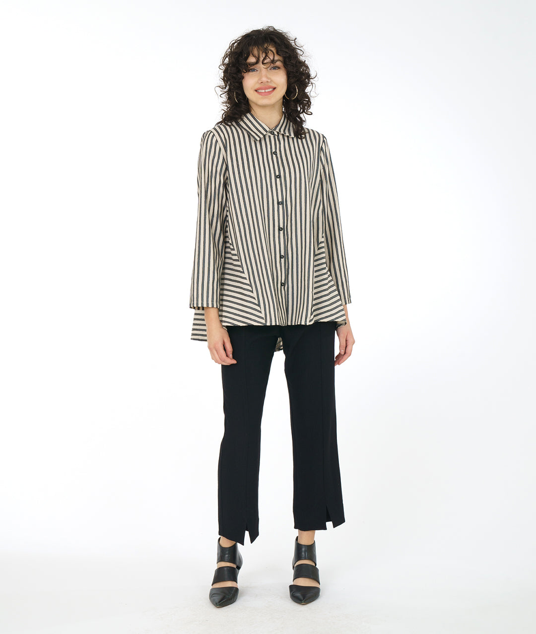 model in a slim black pant with a taupe and black striped blouse with a panel adding body on either side