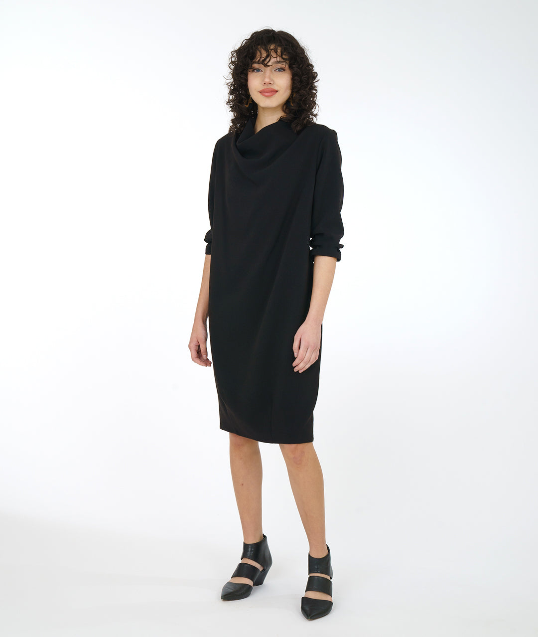 model in a black shift dress with long sleeves and a soft cowl neck