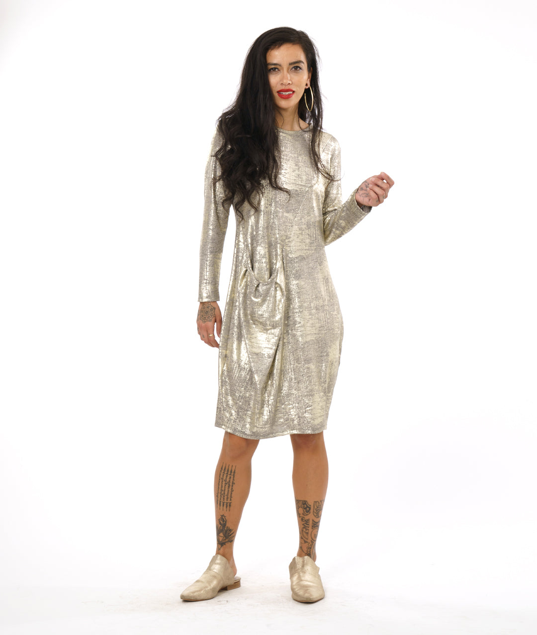 model in a gold metallic dress with an asymmetrical seam across the body with a pleated pocket at the hip