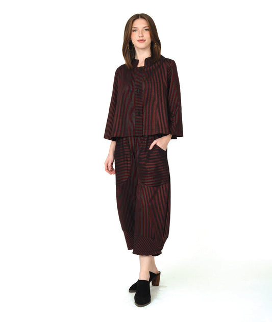 model in a deep red and black striped crop jacket with a matching wide leg pant with tapered ankles and oversized contrasting pockets
