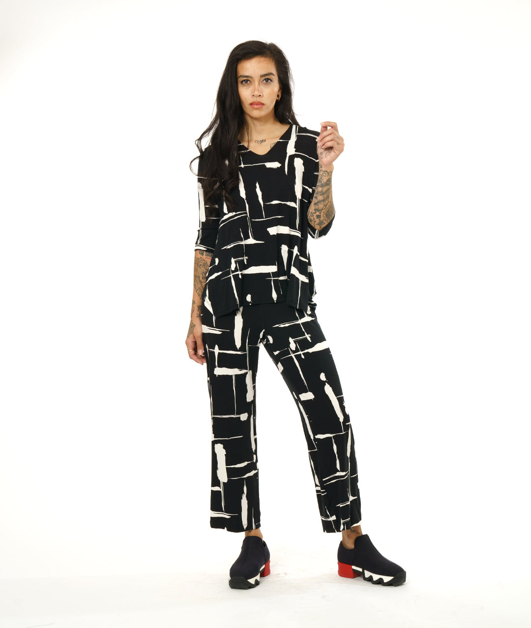 model in a straight leg black and white line print pant, with a matching v-neck top