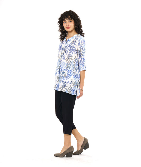 model in a black crop pant worn with a white pullover tunic with a blue and black leaf print. tunic has 3/4 sleeves and a split neckline with shell buttons