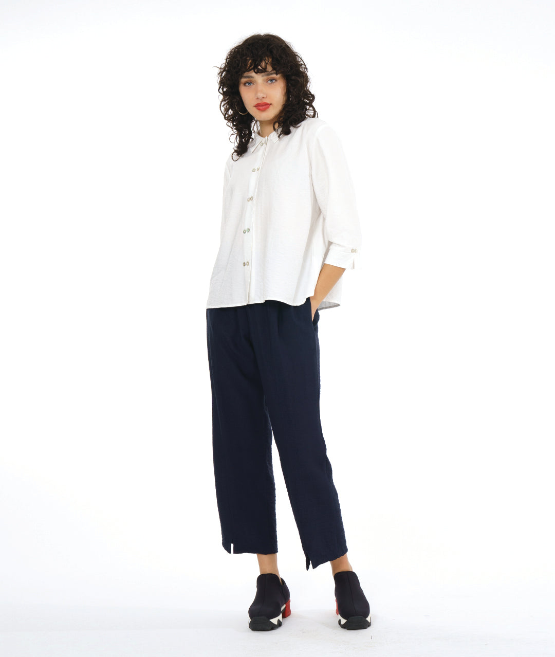 model in a wide leg navy pant worn with a white button down blouse with a twin button detail and 3/4 sleeves