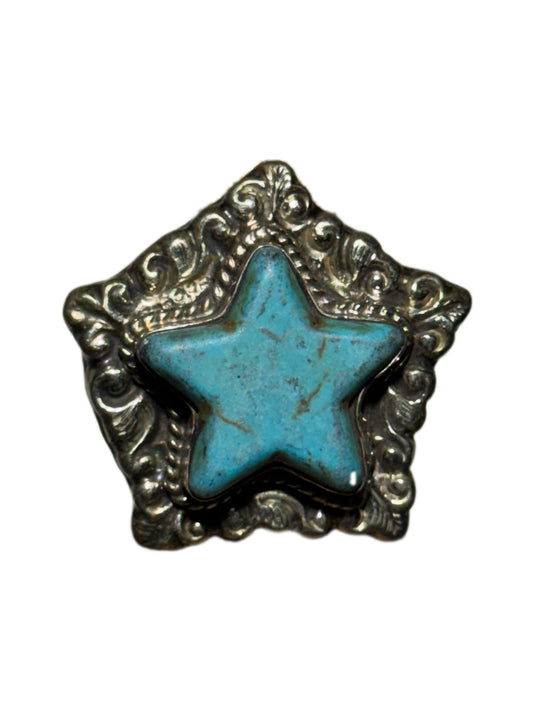 Star-shaped ring with turquoise center and silver decorative border on a white background