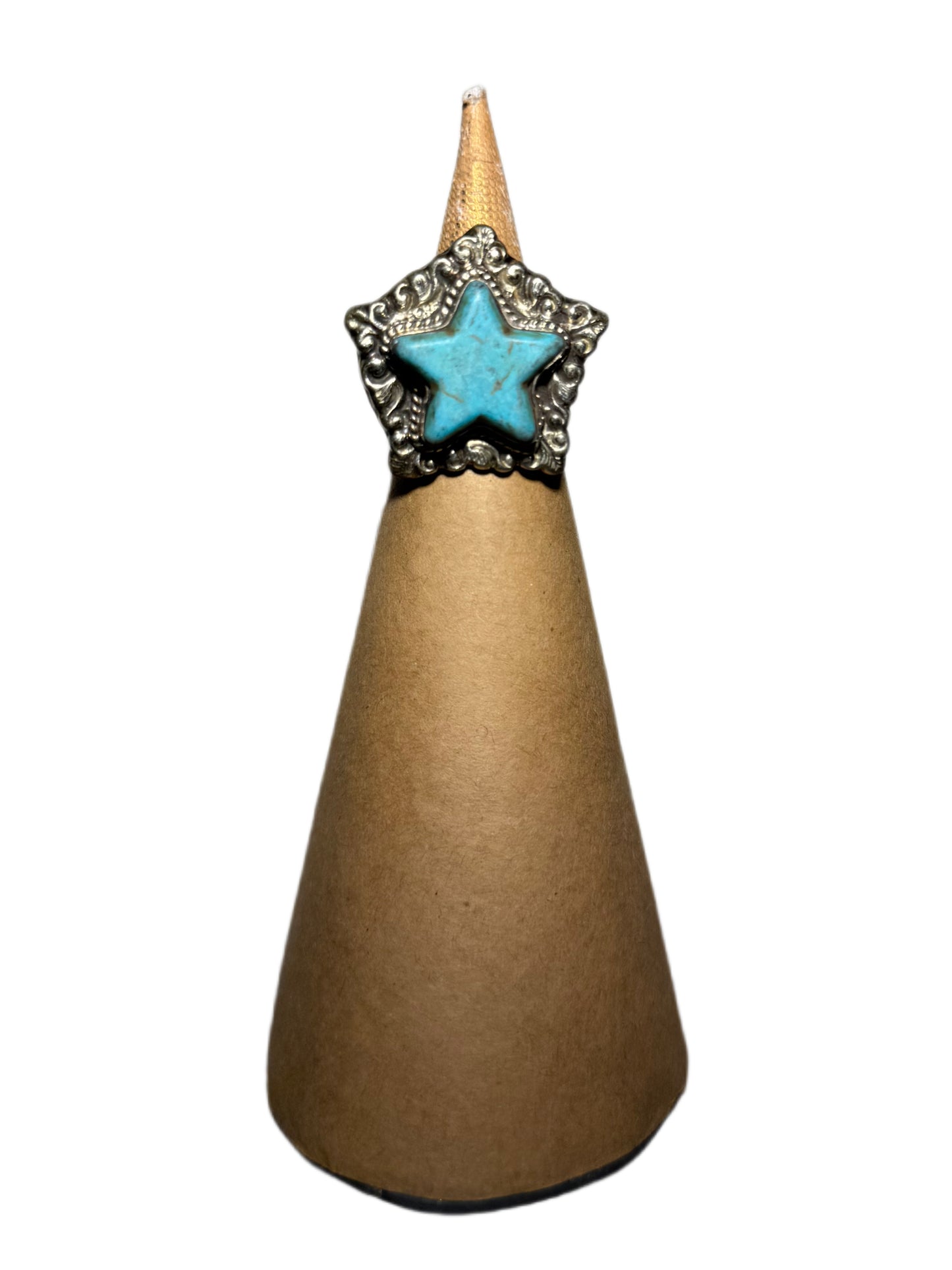 Star-shaped turquoise stone and metallic border ring on a brown cone with a white background