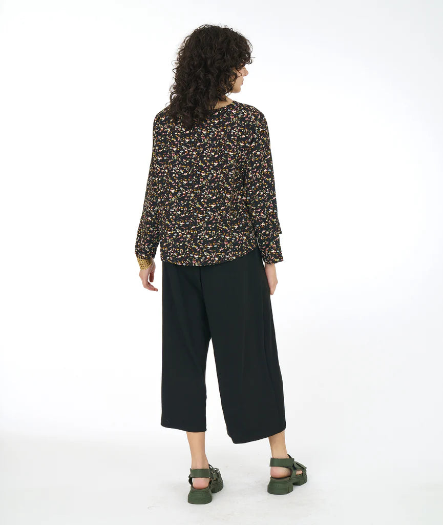 model wearing black terrazzo print long sleeve top with black pants and sandals