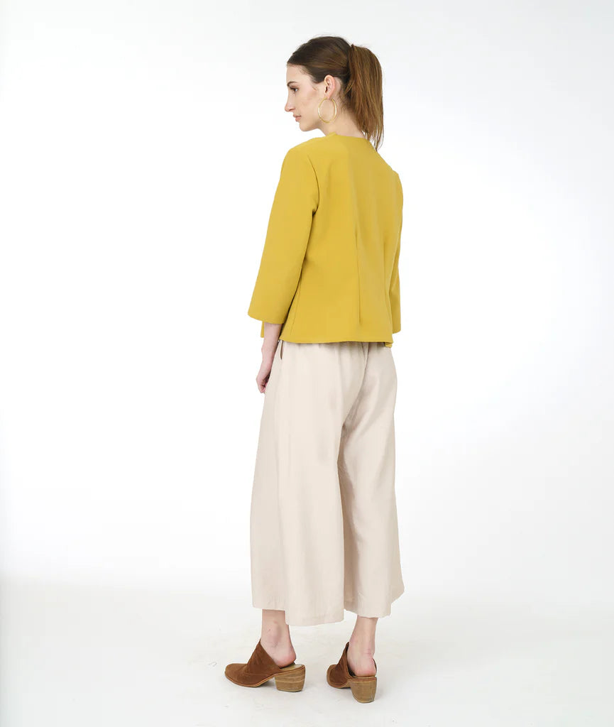 model in a wide leg pearl color pant with a yellow cowl top with 3/4 sleeves