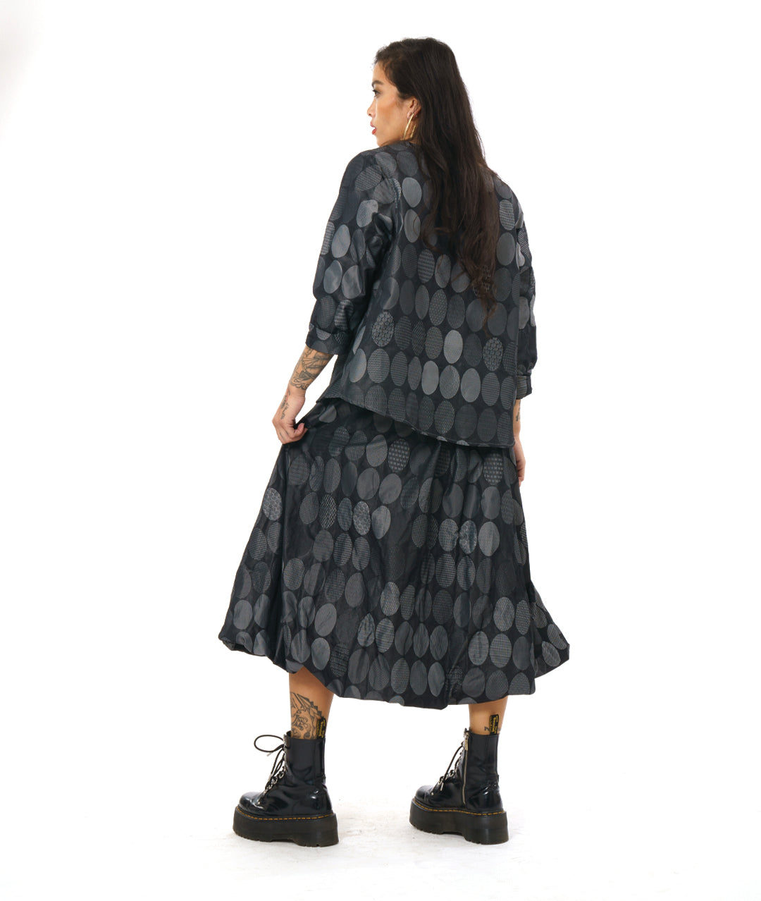 model in a grey oval print bubble skirt, worn with a matching pullover top with long sleeves and a boxy body