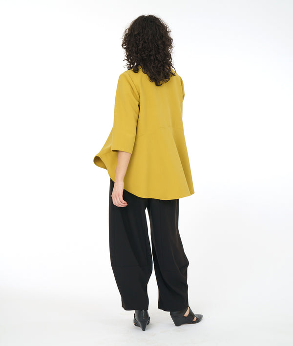 model in a gold yellow pull over top with a high-low hem, 3/4 sleeves and a full bodied back