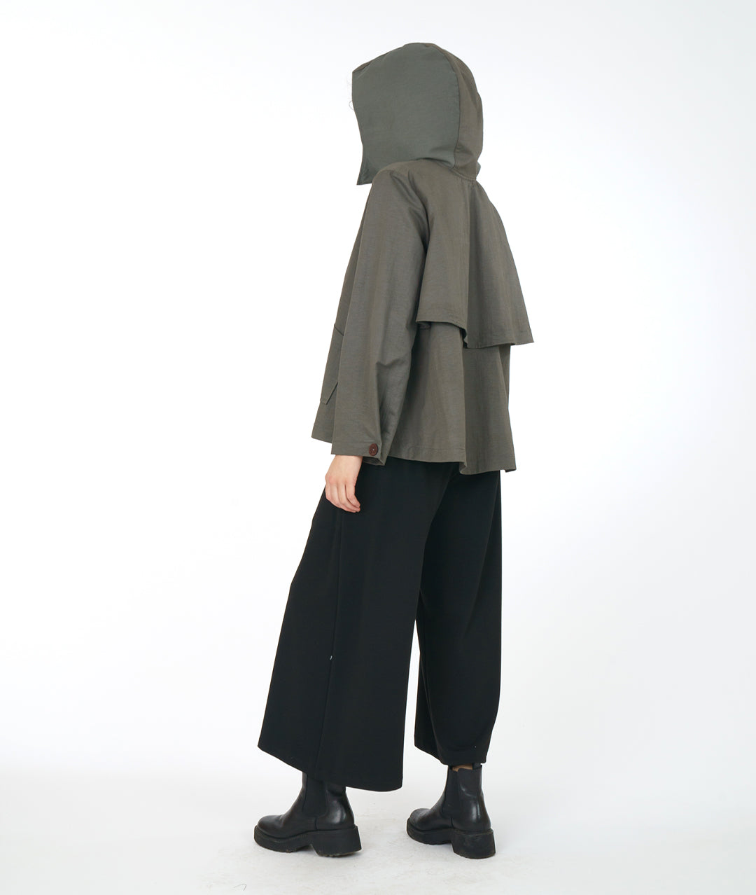 model in a wide leg black pant with a grey, full bodied short jacket with a hood