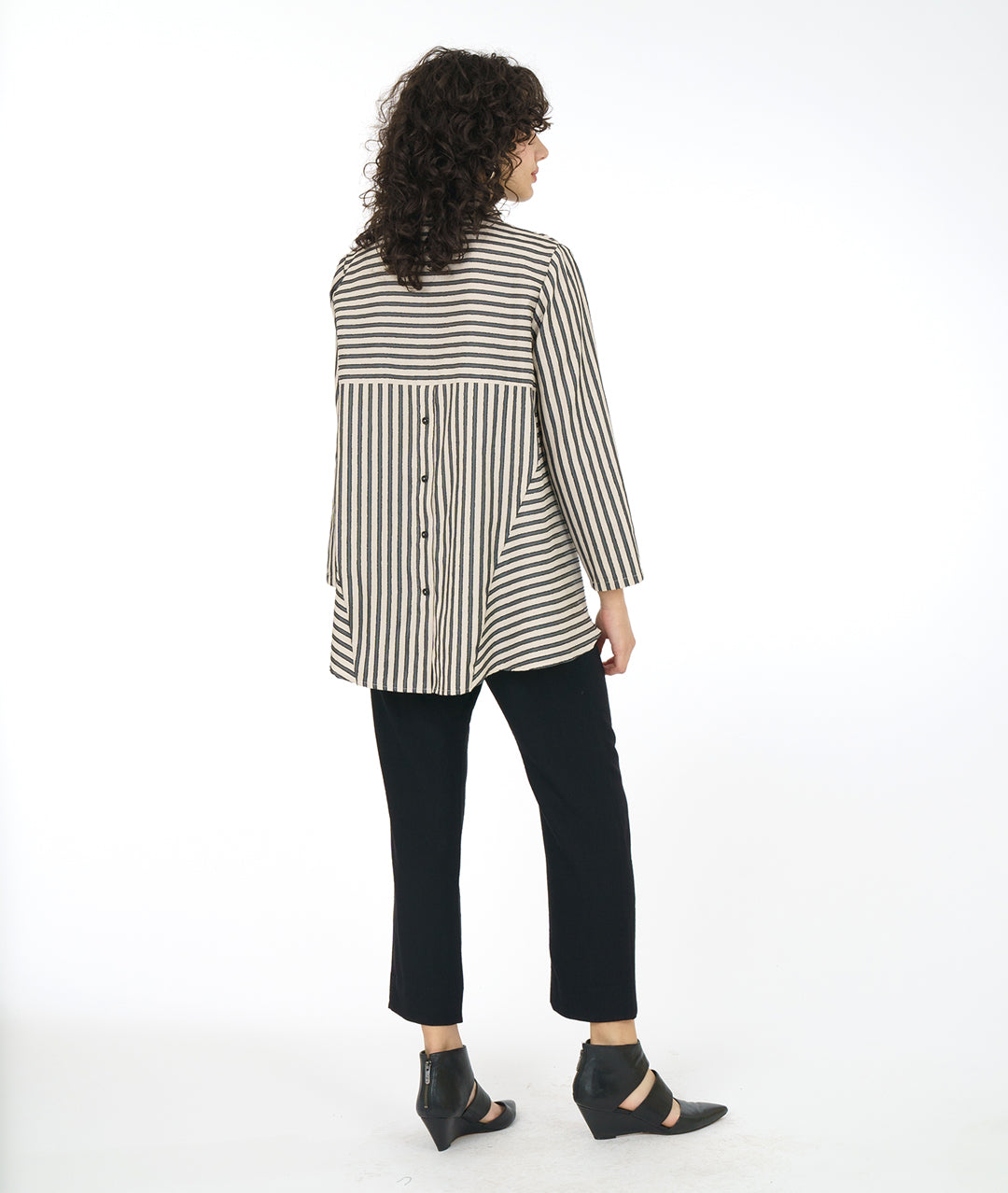 model in a slim black pant with a taupe and black striped blouse with a panel adding body on either side