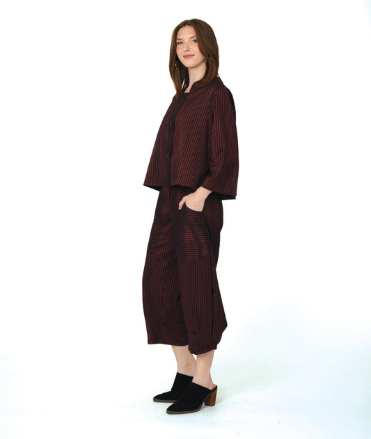 model in a deep red and black striped crop jacket with a matching wide leg pant with tapered ankles and oversized contrasting pockets