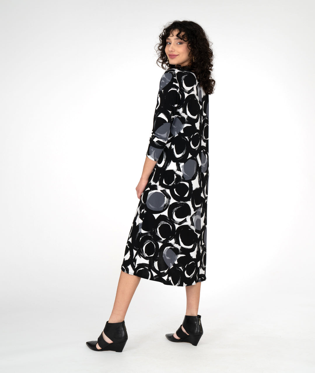 model in a black, white and grey circle print dress with a knot detail on one hip