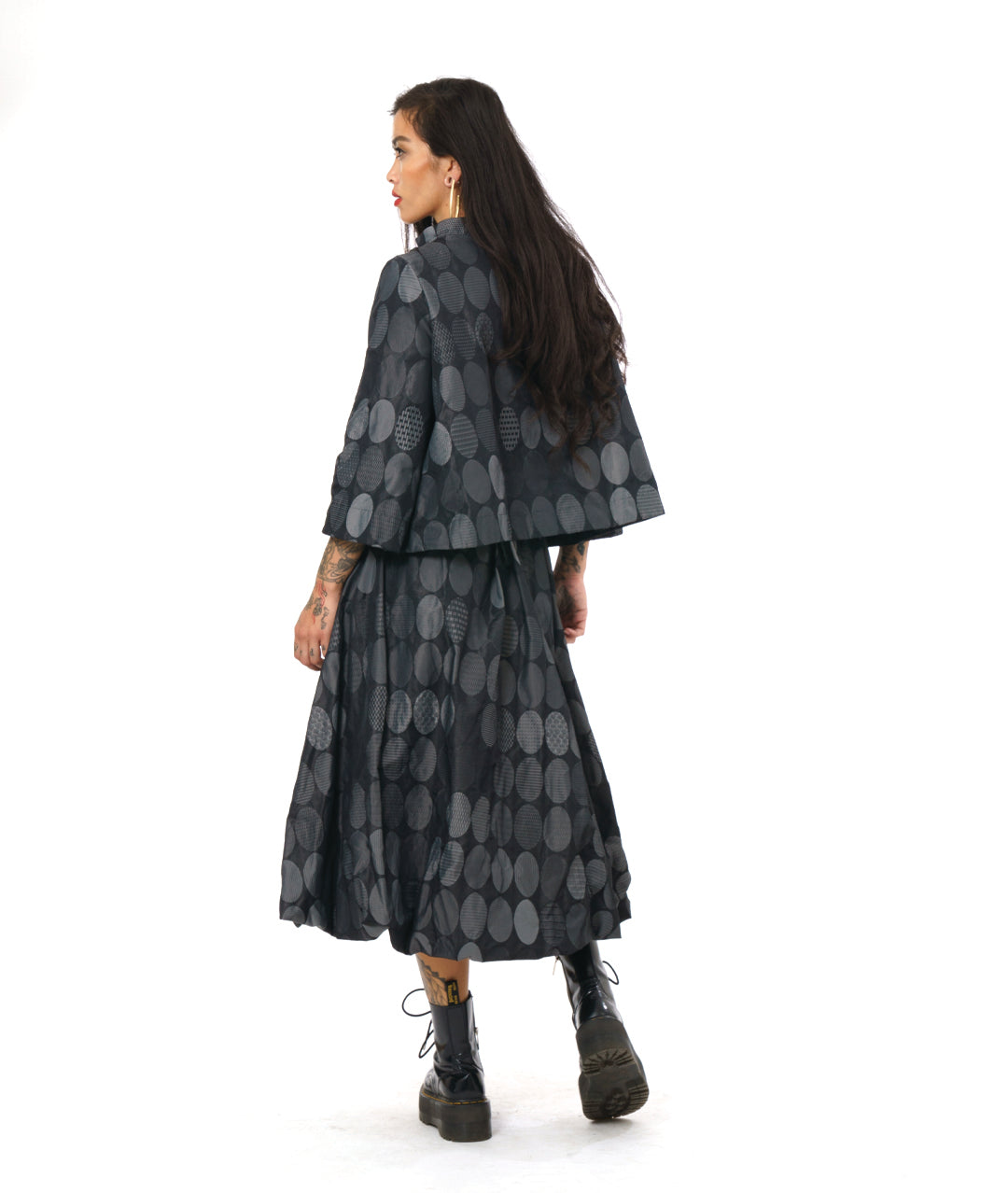 model in a grey oval print bubble skirt, worn with a matching jacket with 3/4 sleeves and a single button closure at the neckline