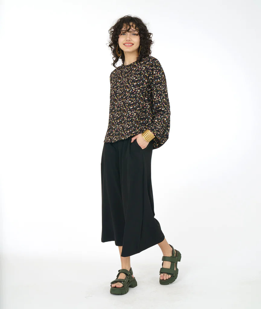 model wearing black terrazzo print long sleeve top with black pants and sandals