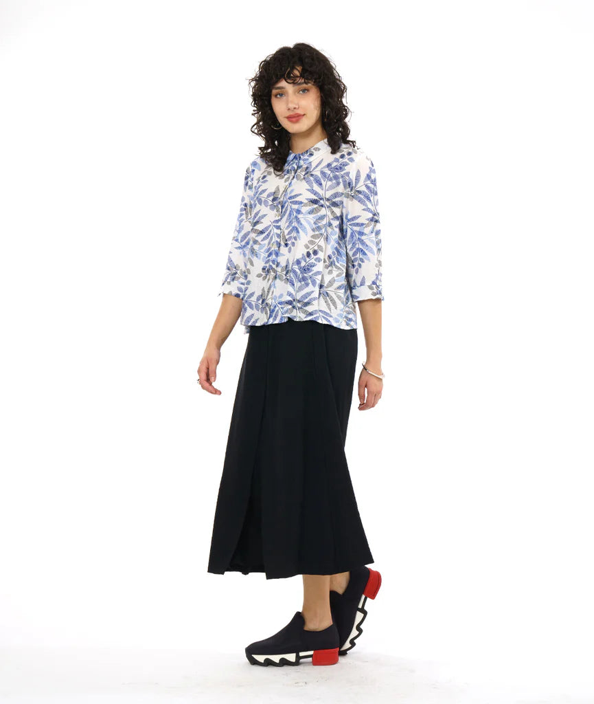 model wearing white button up 3/4 sleeve top with blue and grey leaf print, black pants and black sneakers