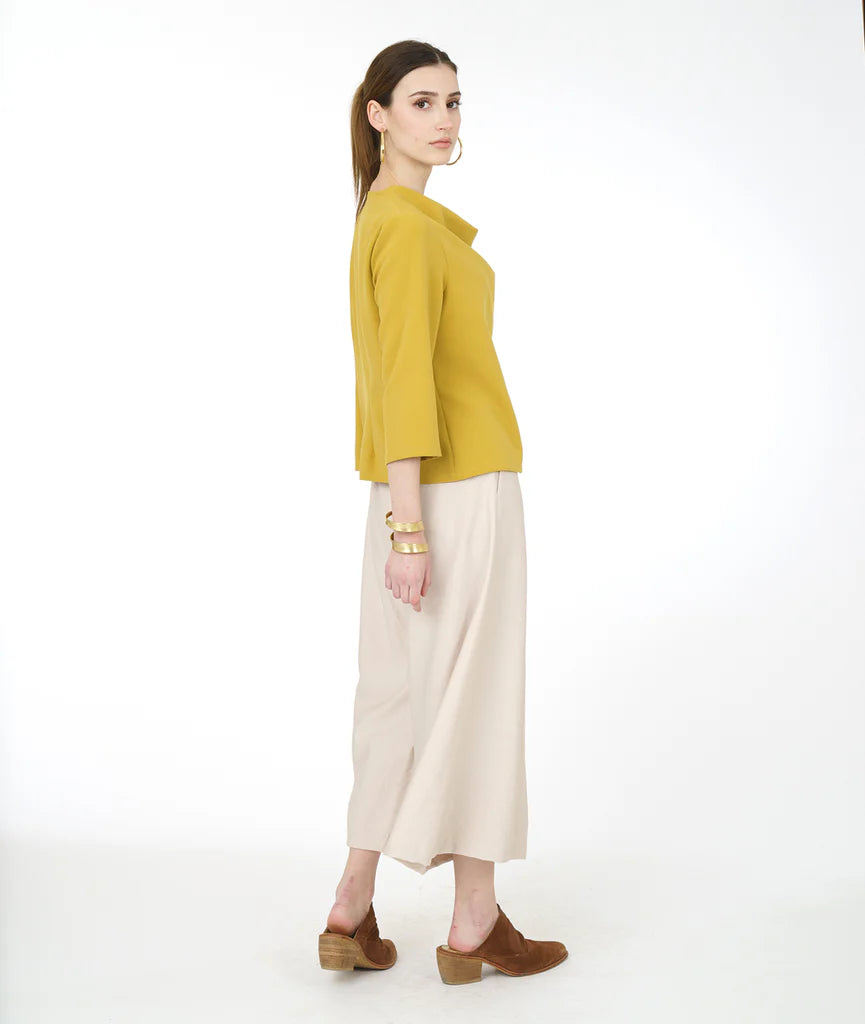 model in a wide leg pearl color pant with a yellow cowl top with 3/4 sleeves