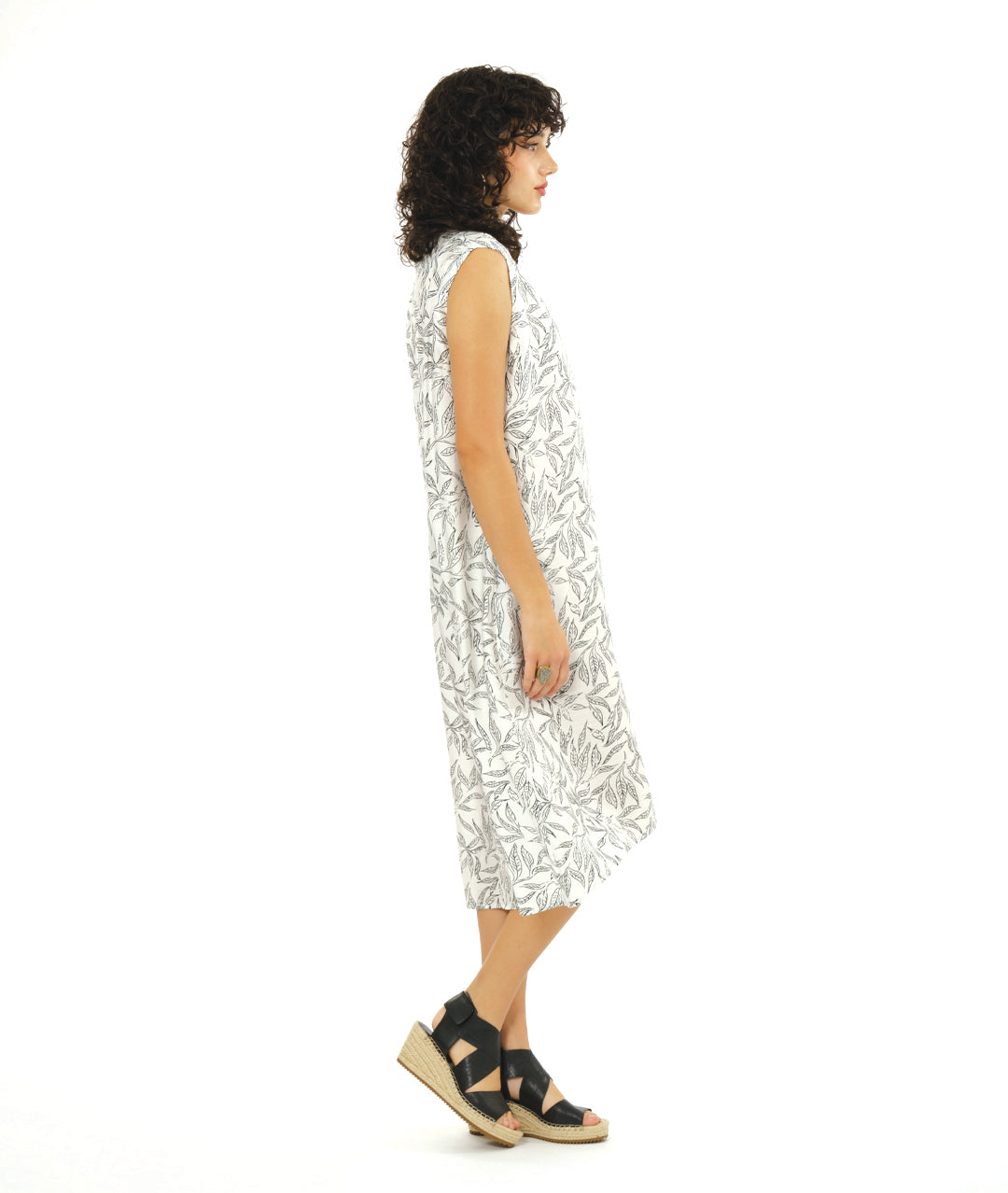 model in a white sleeveless dress with a vneck and a black leaf print