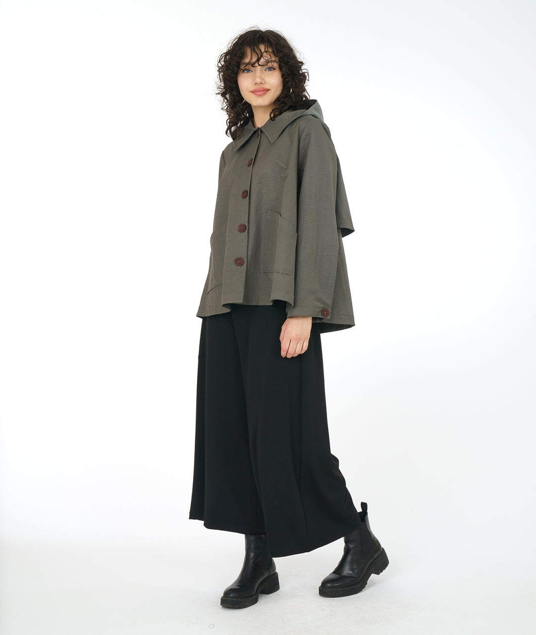 model in a wide leg black pant with a grey, full bodied short jacket with a hood